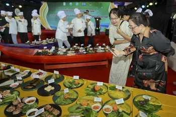 Du khách tham quan, tìm hiểu các loại bánh đạt kỷ lục. (Ảnh: Duy Khương/TTXVN)