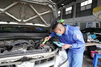 Nhân viên đăng kiểm thực hiện quy trình kiểm định xe cơ giới. (Ảnh: Minh Hiếu/Vietnam+)