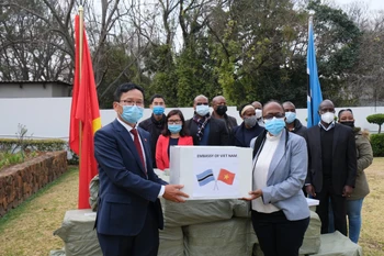Đại sứ Hoàng Văn Lợi trao 50.000 khẩu trang cho Đại biện lâm thời Botswana tại Nam Phi Gaogane Tiny Mothobi trước sự chứng kiến của đại diện Đại sứ quán hai nước. (Ảnh: Hồng Minh/TTXVN)