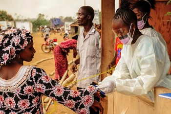 Nhân viên y tế Sierra Leone kiểm tra thân nhiệt của hành khách tại khu vực biên giới với Liberia ở Jendema. (Nguồn: AFP/TTXVN)