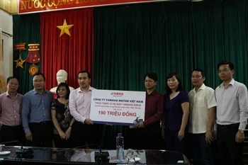 Đại diện Yamaha VN trao biểu trưng 10 xe Sirius cho đại diện chính quyền huyện Mù Căng Chải.