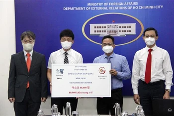 Ông Phạm Minh Tuấn, Phó Chủ tịch Ủy ban Mặt trận Tổ quốc Việt Nam Thành phố (thứ hai từ phải sang) tiếp nhận tượng trưng số khẩu trang do tỉnh Gangwon (Hàn Quốc) trao tặng. (Ảnh: Xuân Khu/TTXVN)