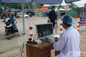 Máy đo thân nhiệt đảm bảo tránh việc tiếp xúc gần. (Nguồn: Báo Nghệ An)