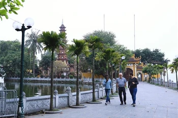 Du khách quốc tế đến vãn cảnh chùa Trấn Quốc. (Ảnh: Hoàng Hiếu/TTXVN)