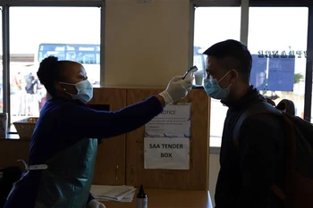  Nhân viên y tế kiểm tra thân nhiệt của hành khách. (Ảnh minh họa. Nguồn: TTXVN)