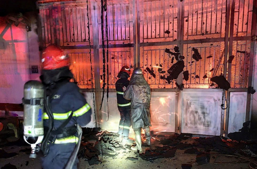 Lực lượng chức năng sử dụng máy cắt khóa cửa chính để dập lửa và cứu nạn, cứu hộ. (Ảnh: TTXVN phát)