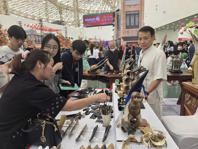 Nghệ nhân Nguyễn Văn Sử, chủ cơ sở mỹ nghệ sừng Mười Sử giới thiệu sản phẩm cho khách hàng. (Ảnh: PV/Vietnam+)