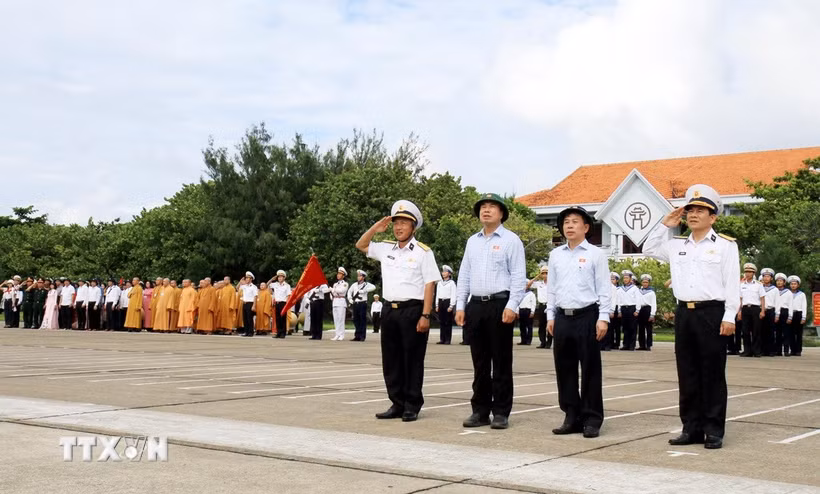 Đoàn công tác thực hiện nghi lễ chào cờ trên đảo Trường Sa. (Ảnh: Thái Thuần/TTXVN)