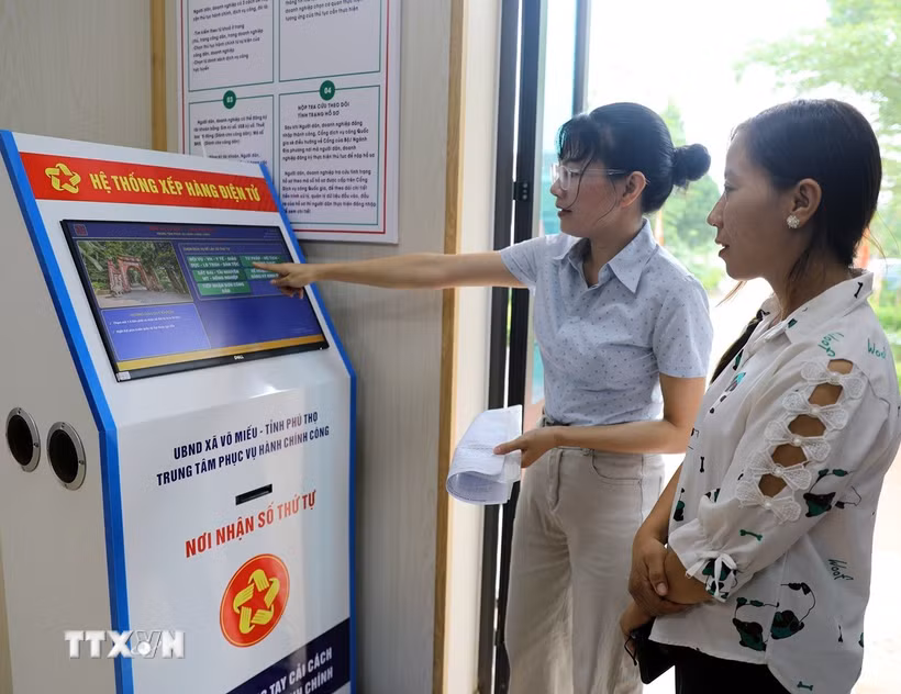 Người dân xã Võ Miếu (Phú Thọ) lấy số tự động, giúp giảm thiểu thời gian chờ đợi và bảo đảm tính công bằng, trật tự khi làm thủ tục. (Ảnh: Tạ Toàn/TTXVN)