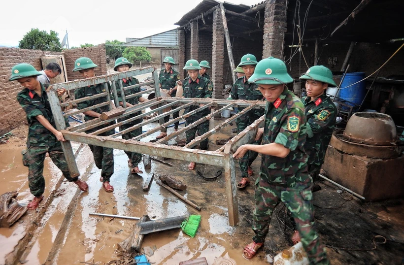 Cán bộ, chiến sỹ Sư đoàn 325 hỗ trợ gia đình anh Nguyễn Văn Hồng, thôn Thủ Dương, xã Nam Dương, huyện Lục Ngạn (Bắc Giang) bị sập nhà do lũ. (Ảnh: Danh Lam/TTXVN)