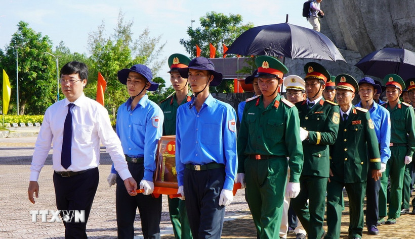 Lãnh đạo tỉnh Đồng Tháp thực hiện nghi thức đưa hài cốt liệt sỹ đến nơi an nghỉ. (Ảnh: Nhựt An/TTXVN)