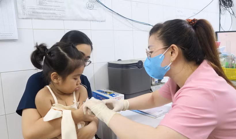 Nhân viên trạm y tế tiêm vaccine phòng sởi cho trẻ. (Ảnh: Đinh Hằng/TTXVN)