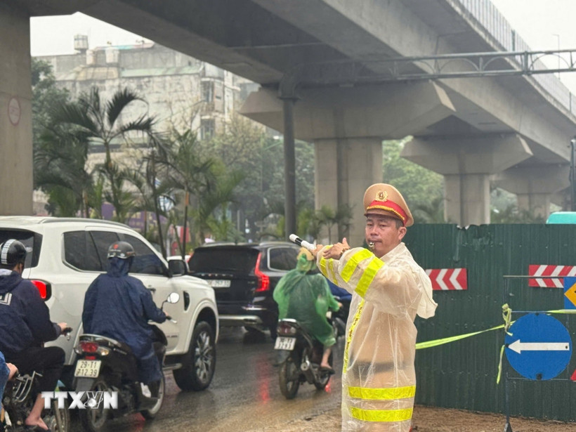 Đội Cảnh sát giao thông đường bộ số 7, Phòng Cảnh sát giao thông (Công an thành phố Hà Nội) phân luồng giao thông tại tuyến đường Nguyễn Trãi, phường Thanh Xuân, sáng 2/4/2026. (Ảnh: Hùng Mạnh/TTXVN)