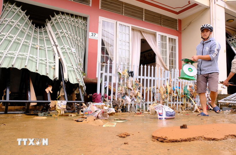 Người dân trên đường Trần Hưng Đạo (trung tâm xã D’ran, Lâm Đồng) quay trở về thu dọn đồ đạc trong sáng 20/11, sau khi nước lũ đã rút bớt. (Ảnh: Nguyễn Dũng/TTXVN)