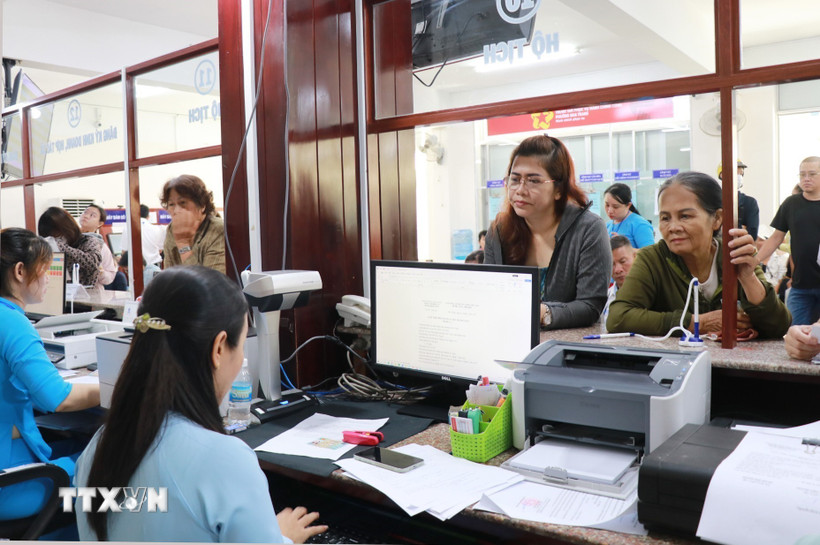 Người dân liên hệ bộ phận một cửa giải quyết các vấn đề liên quan hộ tịch ở phường Nha Trang, tỉnh Khánh Hòa trong ngày làm việc đầu tiên của chính quyền 2 cấp. (Ảnh: Phan Sáu/TTXVN)