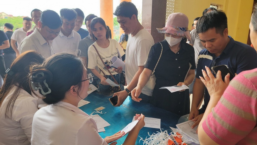 Người dân làm thủ tục trước khi bước vào phiên đấu giá đất tại xã Đình Dù, Văn Lâm (Hưng Yên). (Ảnh: Mạnh Khánh/TTXVN)