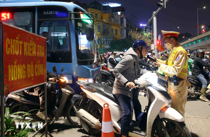 Cán bộ, chiến sỹ cảnh sát giao thông kiểm tra đồng nồng độ cồn với người tham gia giao thông. (Ảnh: Phạm Kiên/TTXVN)