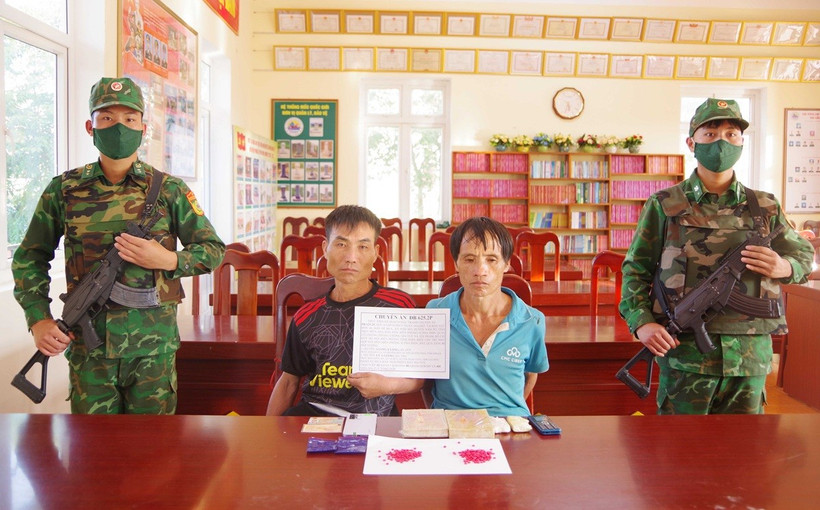 Hai đối tượng cùng tang vật vụ án. (Ảnh: TTXVN phát)