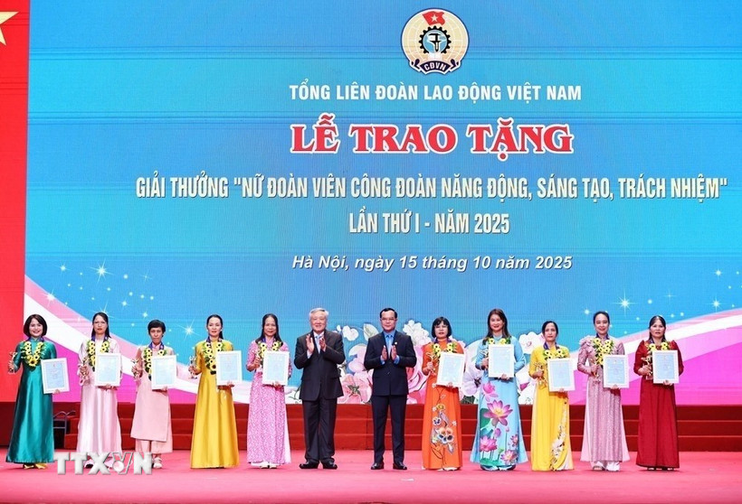 Phó Thủ tướng Thường trực Chính phủ Nguyễn Hòa Bình, Chủ tịch Tổng Liên đoàn Lao động Việt Nam Nguyễn Đình Khang trao tặng biểu trưng và chứng nhận Giải thưởng “Nữ đoàn viên công đoàn năng động, sáng tạo, trách nhiệm” cho 10 cá nhân. (Ảnh: Minh Đức/TTXVN)