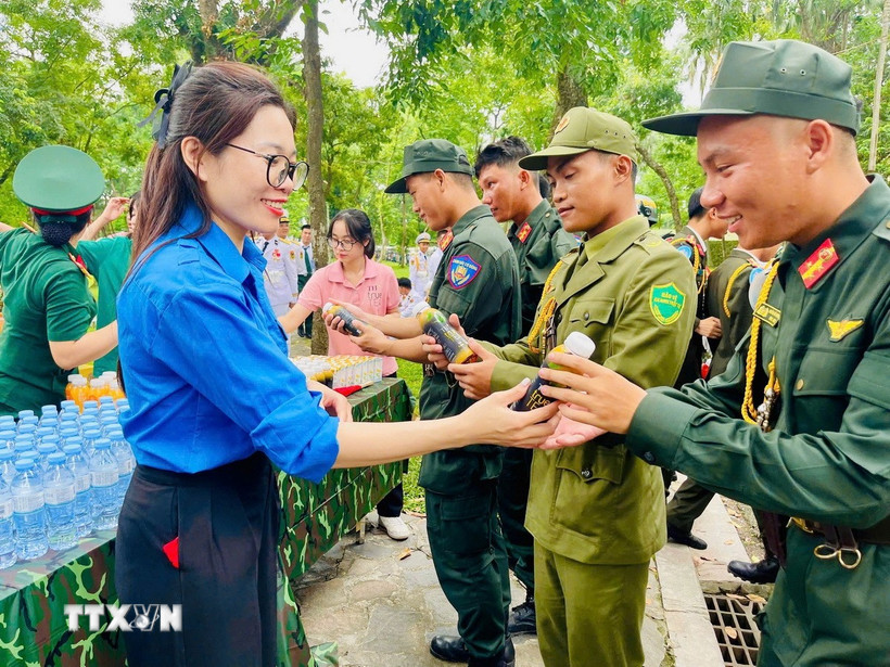 Tình nguyện viên trao nước uống cho các lực lượng làm nhiệm vụ. (Ảnh: TTXVN phát)