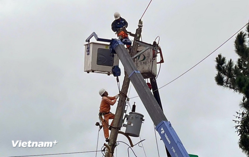 Những công nhân Đội Quản lý điện Đơn Dương miệt mài sửa chữa lưới điện, sớm đưa điện về phục vụ người dân sau trận lũ lịch sử. (Ảnh: PV/Vietnam+)