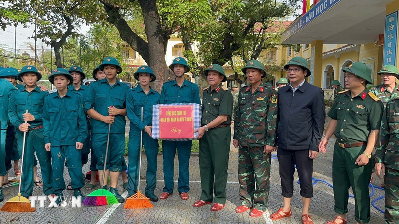 Thượng tướng Trương Thiên Tô trao quà cho các cán bộ chiến sỹ đang hỗ trợ trường Tiểu học Trần Quốc Toản tổng vệ sinh sau ngập lụt. (Ảnh: Văn Dũng/TTXVN)