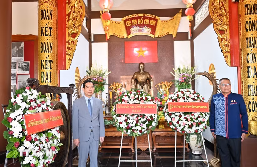 Đại sứ Phạm Việt Hùng (trái) và Tỉnh trưởng tỉnh Nakhon Phanom Adisak Noisuwan dâng hoa kỷ niệm Ngày sinh nhật Bác. (Ảnh: Đỗ Sinh/TTXVN)