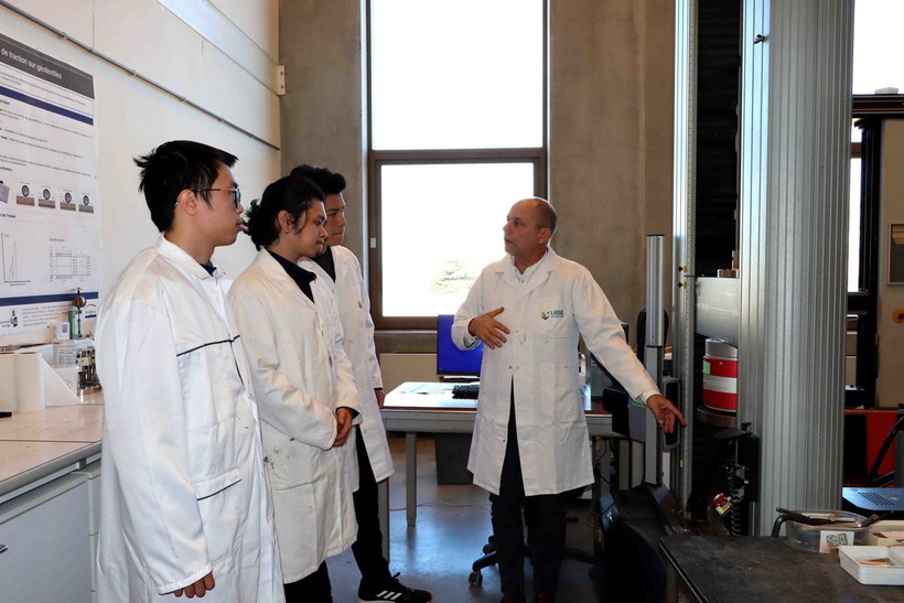 Giáo sư Luc Courard, chuyên gia hàng đầu về vật liệu xây dựng phi kim loại, hướng dẫn nhóm thực tập sinh đến từ Đại học Xây dựng Hà Nội. (Ảnh: Hương Giang/TTXVN)
