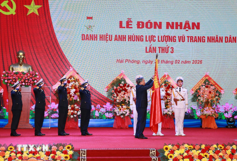 Tổng Bí thư Tô Lâm, Bí thư Quân ủy Trung gắn Huy hiệu Anh hùng Lực lượng Vũ trang nhân dân lên Quân kỳ Quyết thắng của Quân chủng Hải quân. (Ảnh: Trọng Đức/TTXVN)