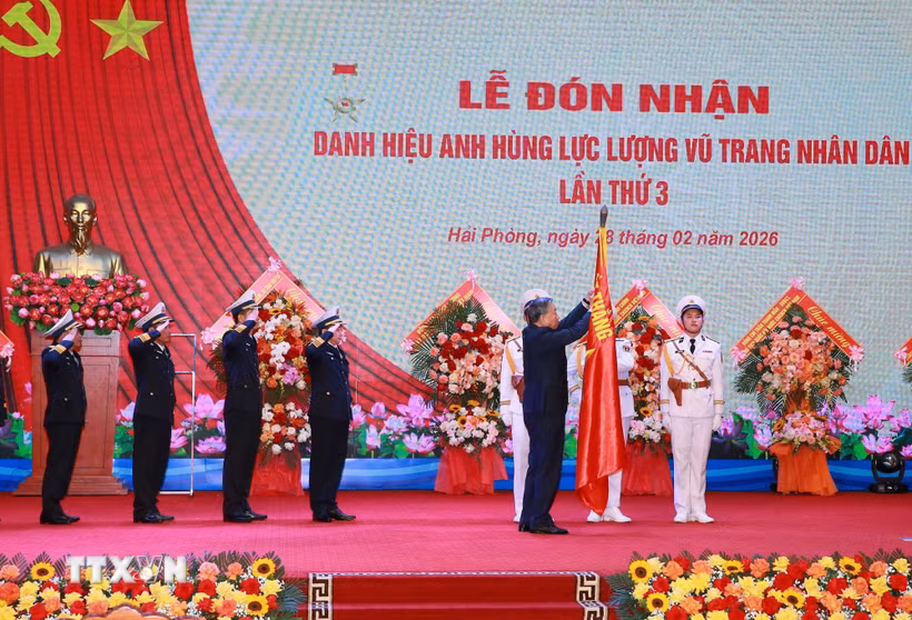 Tổng Bí thư Tô Lâm, Bí thư Quân ủy Trung gắn Huy hiệu Anh hùng Lực lượng Vũ trang nhân dân lên Quân kỳ Quyết thắng của Quân chủng Hải quân. (Ảnh: Trọng Đức/TTXVN)