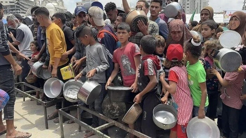 Người dân Palestine nhận thức ăn cứu trợ tại Dải Gaza. (Ảnh: IRNA/TTXVN)