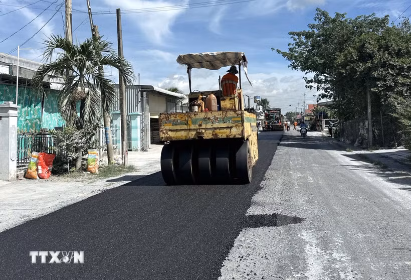 Tranh thủ thời tiết khô ráo, nhà thầu triển khai thảm nhựa Quốc lộ 30, đoạn qua ấp Gò Da, xã Tân Hồng. (Ảnh: Nhựt An/TTXVN)