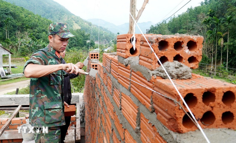 Cán bộ, chiến sỹ Ban chỉ huy Phòng thủ khu vực 1-Sơn Tịnh (Bộ chỉ huy Quân sự tỉnh Quảng Ngãi) gấp rút triển khai thi công nhà ở cho các hộ dân Tây Trà. (Ảnh: Lê Phước Ngọc/TTXVN)