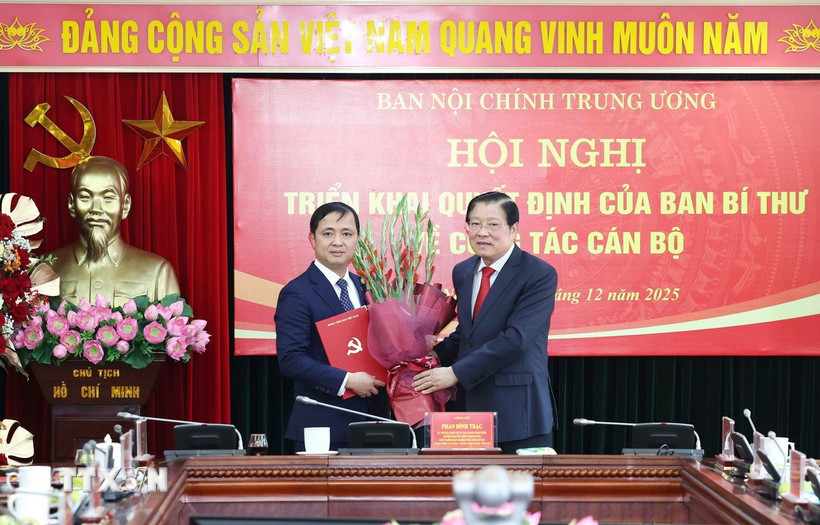 Ông Phan Đình Trạc, Ủy viên Bộ Chính trị, Bí thư Trung ương Đảng, Trưởng Ban Nội chính Trung ương trao Quyết định của Ban Bí thư cho ông Nguyễn Xuân Trường. (Ảnh: Phương Hoa/TTXVN)