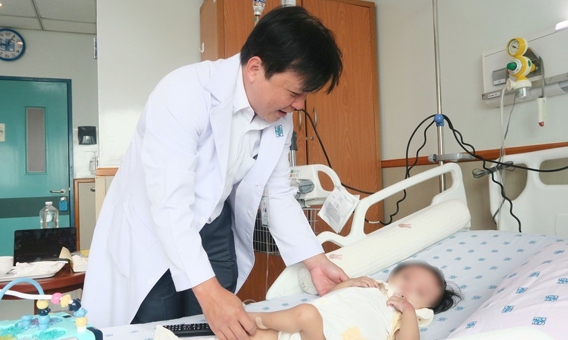 Tiến sỹ, bác sỹ Trần Công Duy Long thăm khám cho bệnh nhi trước ca ghép gan. (Ảnh: Đinh Hằng/TTXVN)