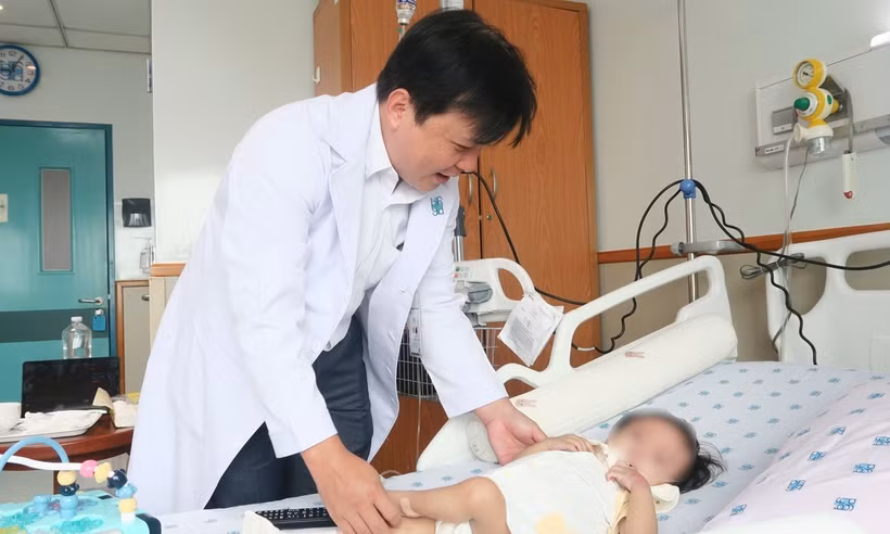 Tiến sỹ, bác sỹ Trần Công Duy Long thăm khám cho bệnh nhi trước ca ghép gan. (Ảnh: Đinh Hằng/TTXVN)