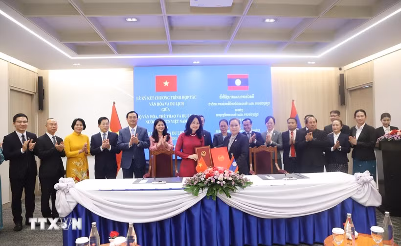 Bộ trưởng Bộ Văn hóa, thể thao và du lịch Việt Nam Lâm Thị Phương Thanh và Bộ trưởng Bộ Văn hóa và thể thao Lào Suonsavan Vinhaket trao đổi văn kiện hợp tác. (Ảnh: Xuân Tú/TTXVN)