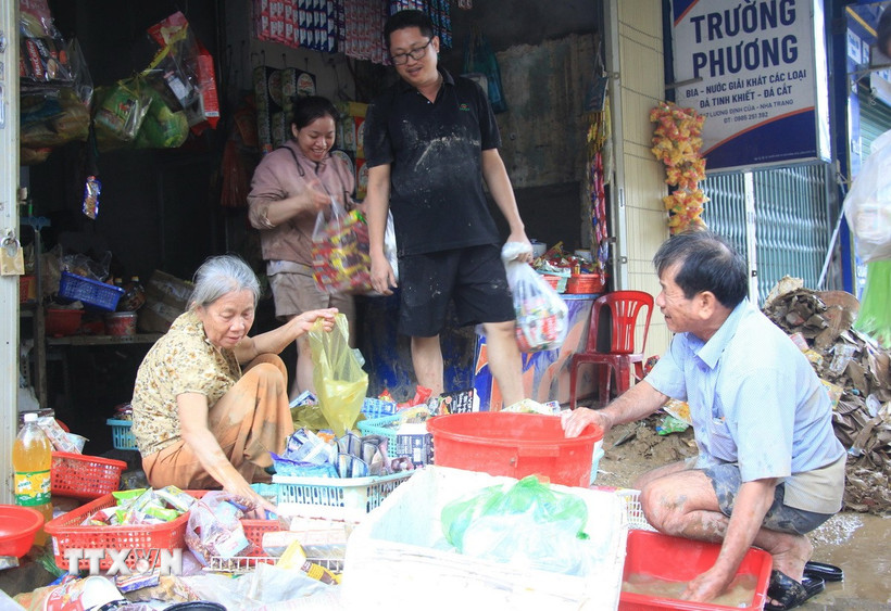 Người dân phường Tây Nha Trang, tỉnh Khánh Hòa lau dọn những nhu yếu phẩm còn sử dụng được sau ngập lụt. (Ảnh: Phan Sáu/TTXVN)