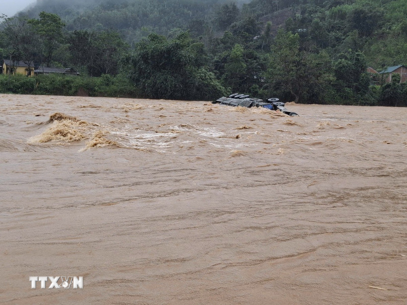 Chiếc xe container vượt ngầm tràn, tài xế bị lũ cuốn trôi mất tích. (Nguồn: TTXVN phát)