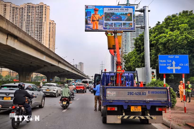 Lực lượng chức năng và đơn vị thi công kiểm tra, hoàn thiện hệ thống bảng thông tin giao thông điện tử trước khi đưa vào vận hành. (Ảnh: Trung Nguyên/TTXVN)