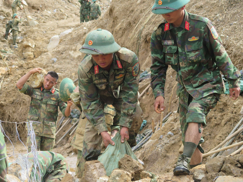 Cán bộ, chiến sỹ Quân đoàn 34 triển khai công tác mở đường vào các thôn bị cô lập do mưa lũ ở xã Ngọc Linh. (Ảnh: Dư Toán/TTXVN)