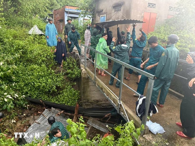 Cán bộ, chiến sỹ Đồn biên phòng cửa khẩu cảng Nha Trang phối hợp cùng các lực lượng địa phương tổ chức khơi thông các kênh, rãnh thoát nước không để tắc nghẽn. (Nguồn: TTXVN phát)