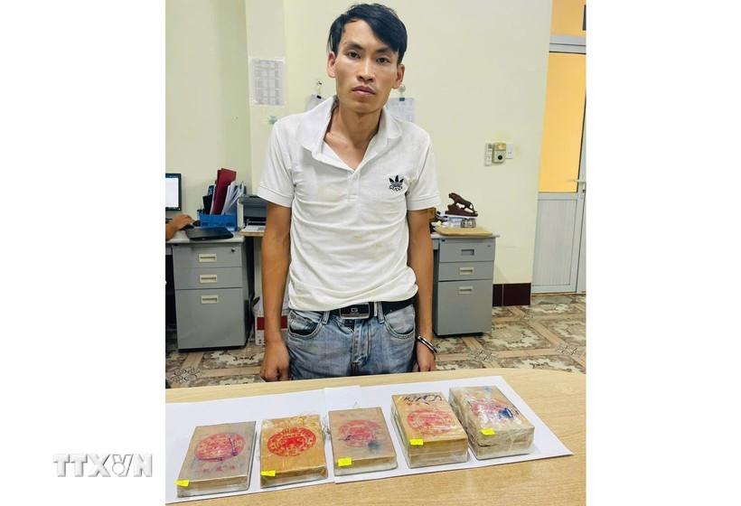Đối tượng Dương Văn Cai và số heroin tang vật vụ án. (Ảnh: TTXVN phát)