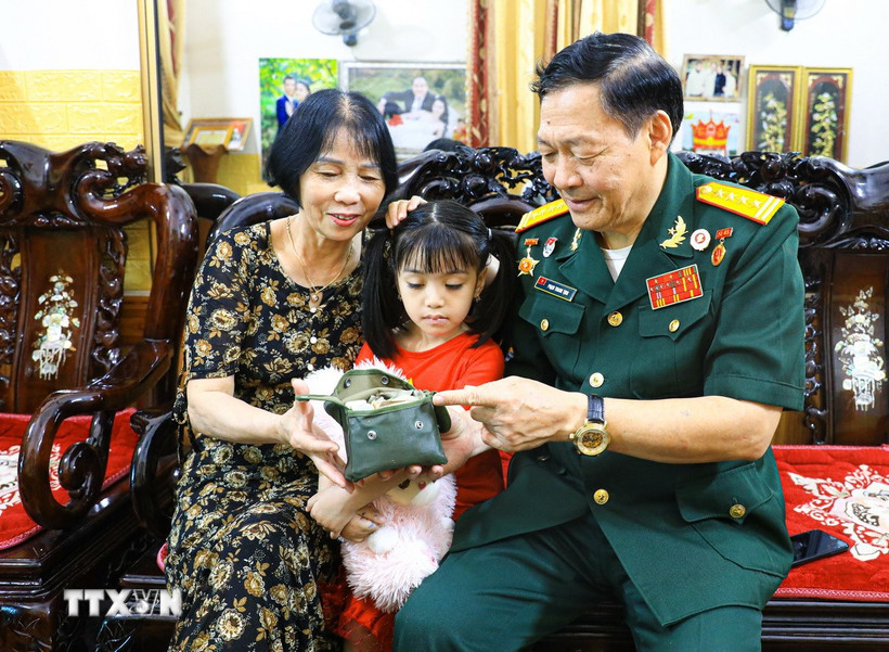 Cựu chiến binh Phạm Thanh Tịnh xem lại kỷ vật trong chiến trường xưa. (Ảnh: Phan Quân/TTXVN)