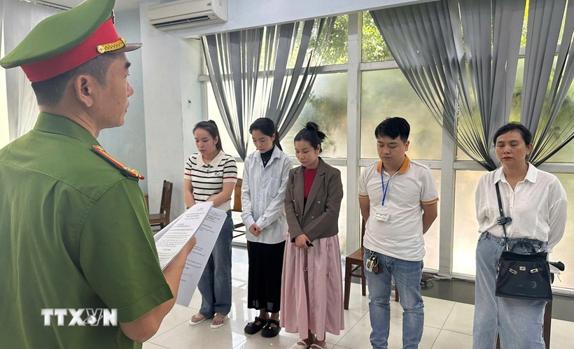 Lực lượng chức năng đọc lệnh Khởi tố tại việc Phòng khám Đa khoa Quốc tế Đà Nẵng. (Nguồn: TTXVN phát)