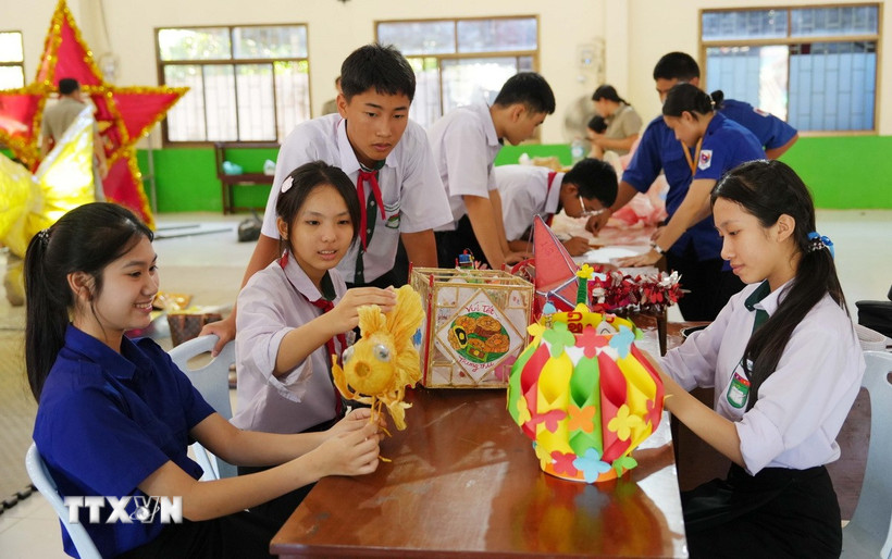 Các em học sinh Việt Nam-Lào háo hức chuẩn bị Tết Trung thu. (Ảnh: Xuân Tú/TTXVN)