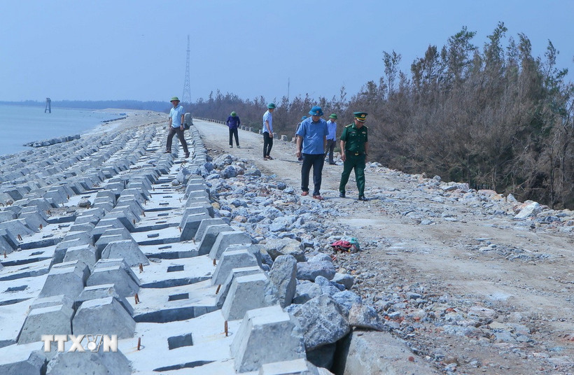 Các lực lượng chức năng đi kiểm tra vị trí xung yếu tại khu vực kè Hải Thịnh. (Ảnh: Công Luật/TTXVN)