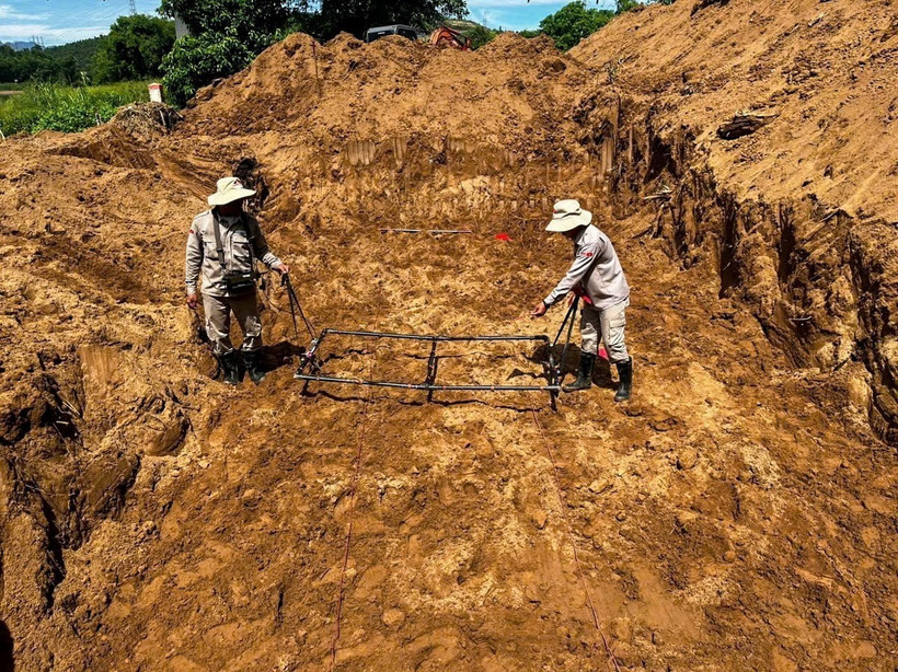 Các kỹ thuật viên Dự án Peace Trees VietNam Quảng Bình rà phá vật liệu nổ tại bến phà Long Đại II. (Ảnh: TTXVN phát)