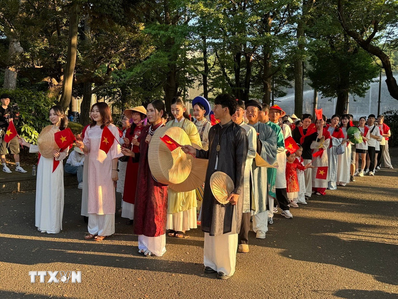 Hơn 200 người Việt và bạn bè Nhật Bản đi bộ trong trang phục áo dài truyền thống của Việt Nam. (Nguồn: TTXVN)