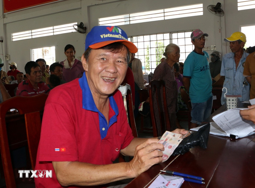 Người dân phường Ngã Năm phấn khởi nhận quà Quốc khánh 2/9 từ Chính phủ. (Ảnh: Tuấn Phi/TTXVN)